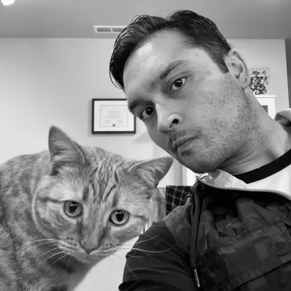 a black and white photo of a cat and human man